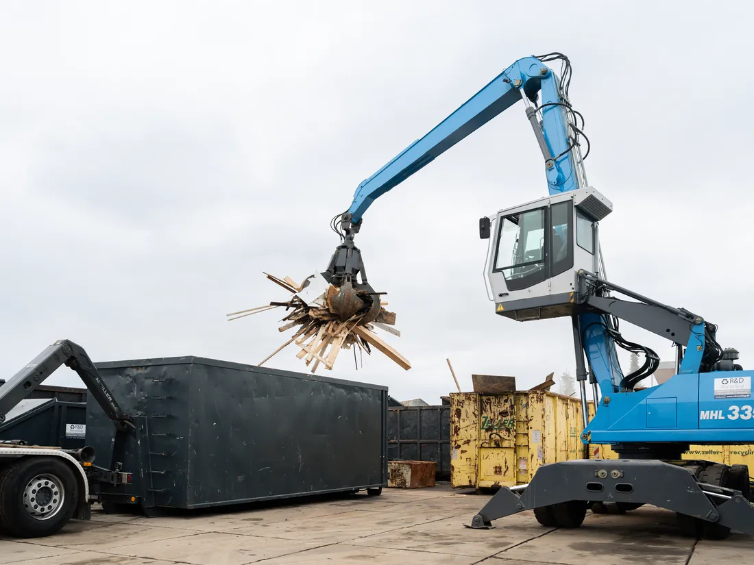 Umschlagbagger von R&D Recycling belädt einen Container mit Schrott